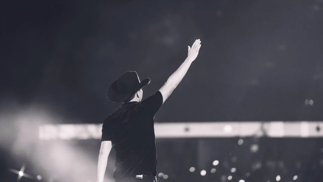 Imagen a blanco y negro de Yeison Jiménez de espalda en medio de un concierto